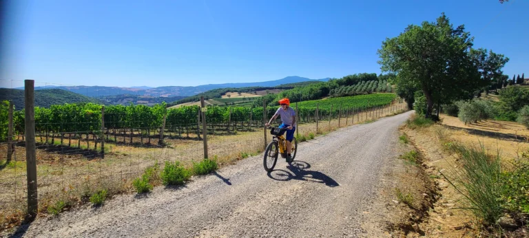 primo viaggio in bici nelle campagne toscane, ragazzo che pedala su sentiero di campagna con tour operator HMO viaggi